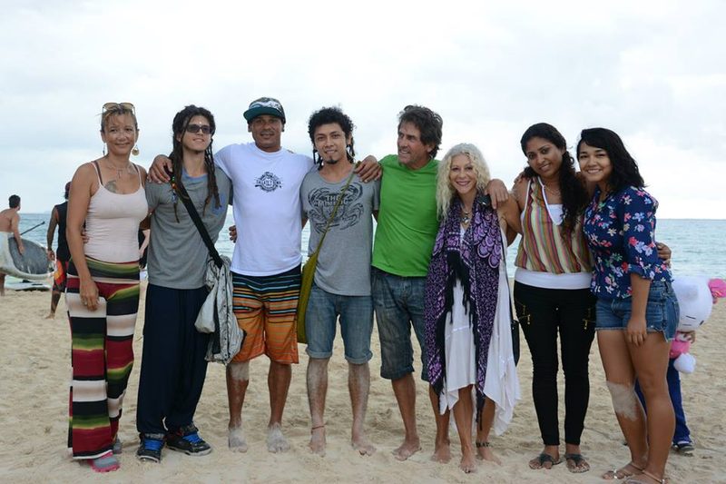 A group of people standing arm in arm on a beach